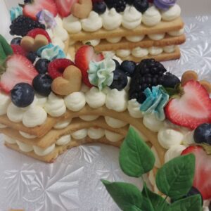 Number cake with layers and fruits and petals